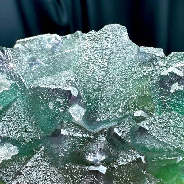 Translucent mint-green octahedral fluorite plate with purple edges from Zhejiang, China, close-up of the crystal faces
