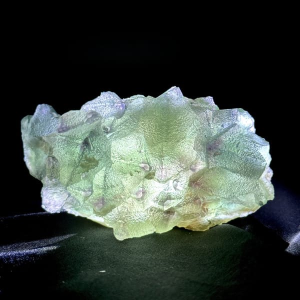 Translucent mint-green octahedral fluorite plate with purple edges from Zhejiang, China, detail of the matrix contact