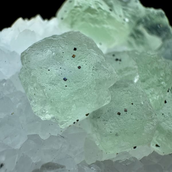 Pale green fluorite cubes in white quartz with pyrite from Jiangxi, China, close-up of the crystal faces