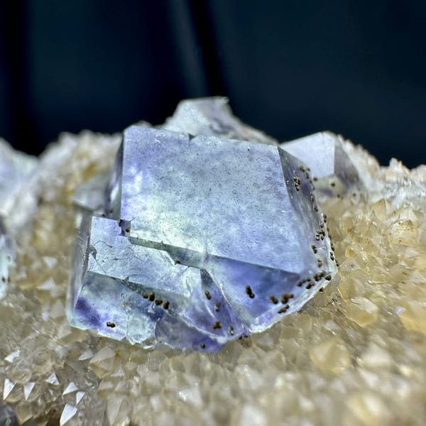 Lavender-blue fluorite dodecahedra with pyrite on quartz druse from Fujian, China, close-up