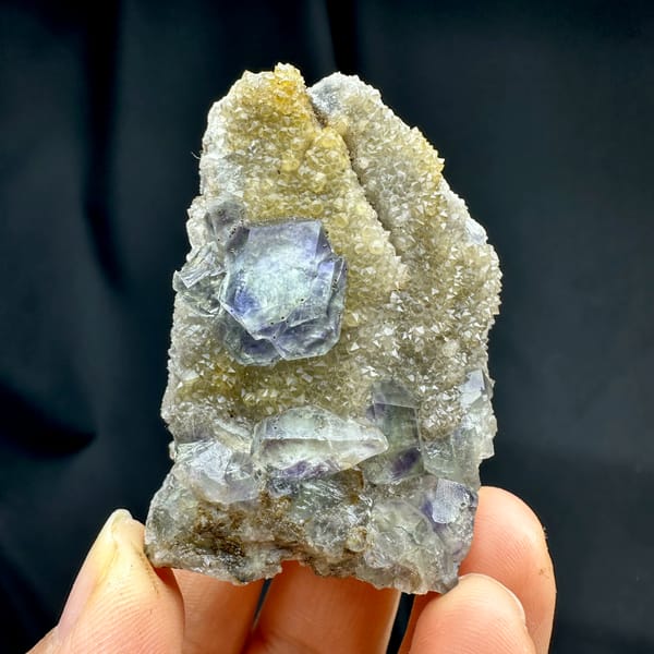 Lavender-blue fluorite dodecahedra with pyrite on quartz druse from Fujian, China, top view
