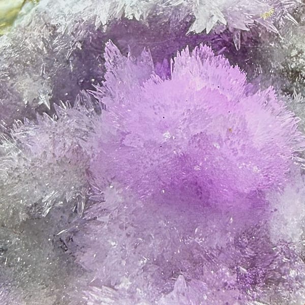 Sparkling magenta aragonite on dark wedge from Yunnan, China, close-up of the crystal faces
