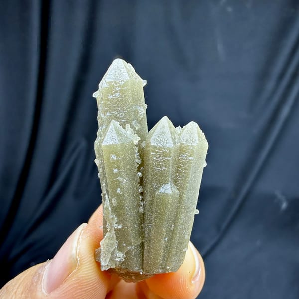 Grey-green quartz prisms with apophyllite from Inner Mongolia, China, held in hand