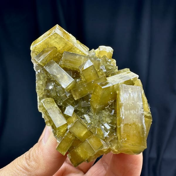 Glassy golden baryte blades with pale fluorite from Jiangxi, China, held in hand