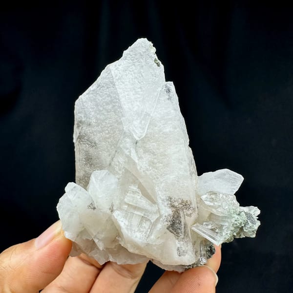 Calcite crystals with quartz, from Guangdong, China, front view in daylight, held in hand
