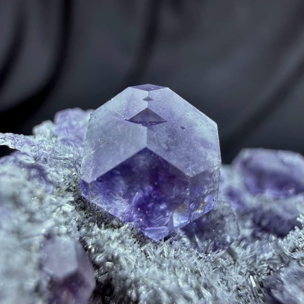 Violet-blue fluorite cubes on grey quartz druse from Fujian, China, close-up of the crystal faces