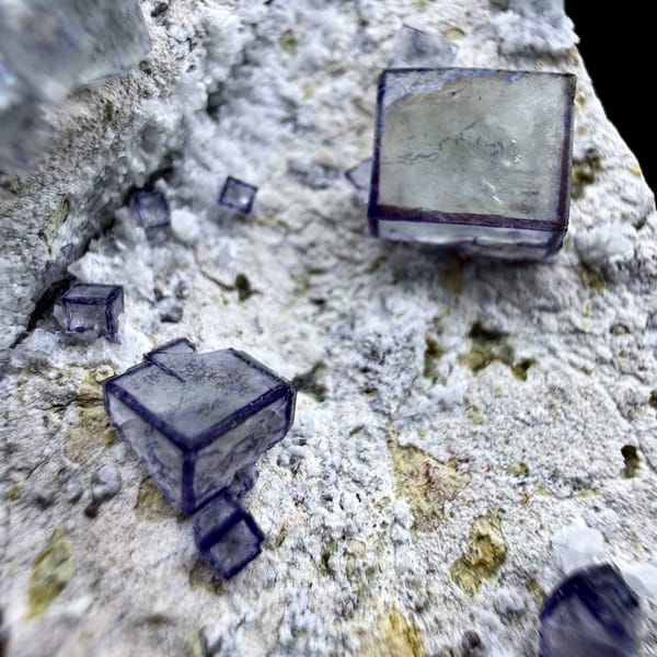 Purple-framed clear fluorite cubes on grey quartz from Inner Mongolia, China, close-up of the crystal faces