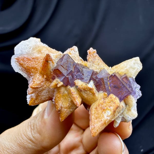 Purple-red fluorite cubes between tan calcite blades from Yunnan, China, top view