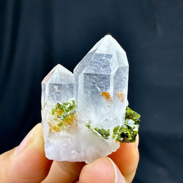 Two clear quartz points with epidote cluster from Sichuan, China, held in hand