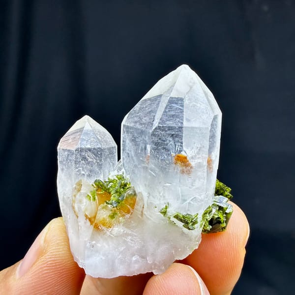 Two clear quartz points with epidote cluster from Sichuan, China, close-up of the crystal faces