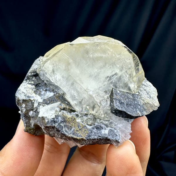 Calcite crystal, from Fujian, China, front view in daylight, held in hand