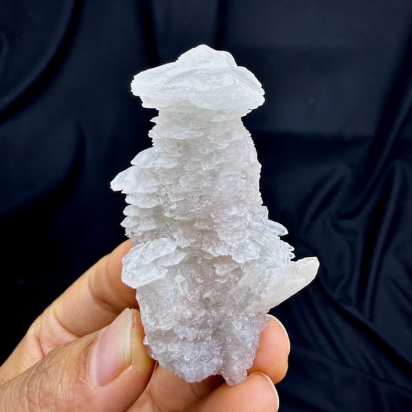 Layered calcite floater, from Fujian, China, front view in daylight, held in hand