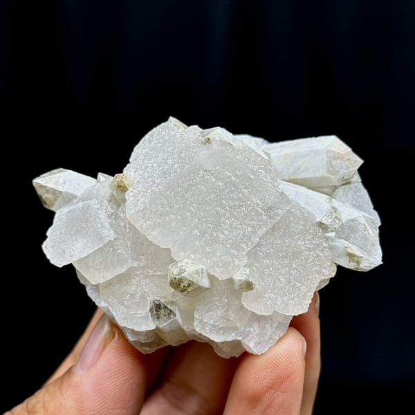 Star calcite with candle quartz, from Inner Mongolia, China, front view in daylight, held in hand