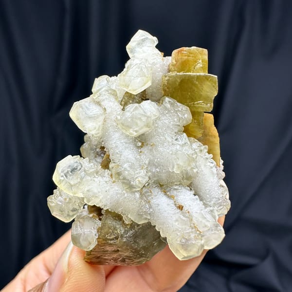 White calcite prisms on golden-brown siderite from Guizhou, China, close-up of the crystal faces