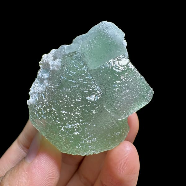 Pale green stepped fluorite crystal with sugary skin from Xianghualing, Hunan, China, close-up of the crystal faces
