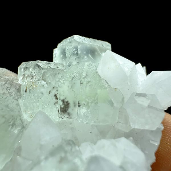 Pale green fluorite cubes with inclusions on white quartz from Guangdong, China, close-up of the crystal faces