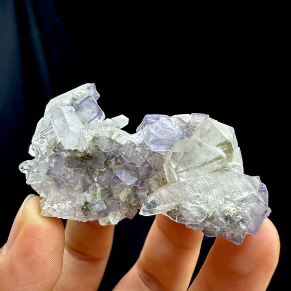 Pale lavender fluorite cubes with white quartz from Yaogangxian Mine, Hunan, China, held in hand