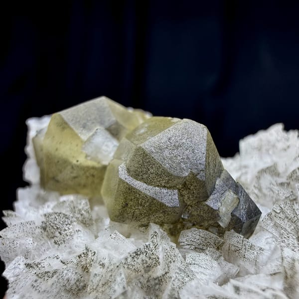 Pale yellow calcite crystal on cream dolomite rhombs from Guizhou, China, close-up of the crystal faces