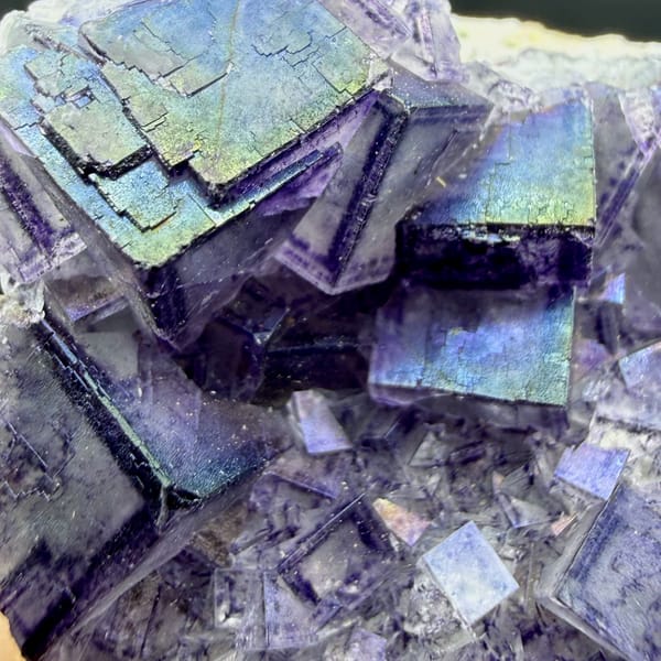 Iridescent purple-framed fluorite cubes with rainbow film from Inner Mongolia, China, close-up of the crystal faces