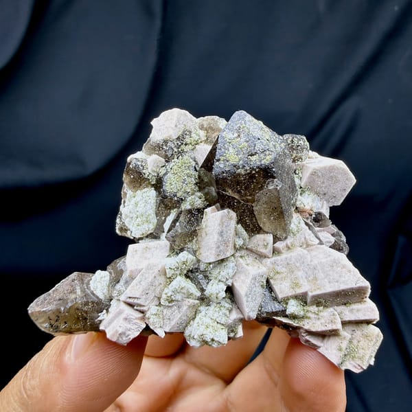 Dark smoky quartz crystals with cream feldspar and mica from Yunxiao, Fujian, China, detail of the matrix contact