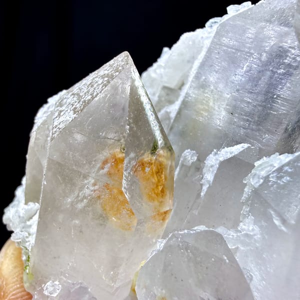 Clear garden-quartz cluster with orange inclusion from Sichuan, China, close-up of the crystal faces