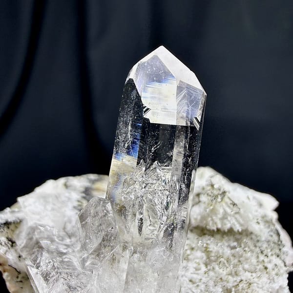 Tall clear quartz prism rising from cream feldspar from Yunxiao, Fujian, China, close-up of the crystal faces