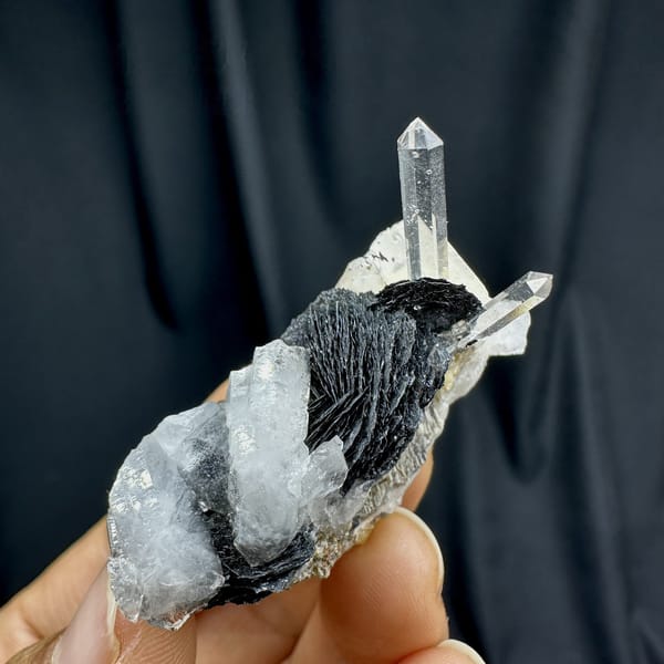 Clear quartz spire on black specular hematite plate from Guangdong, China, top view
