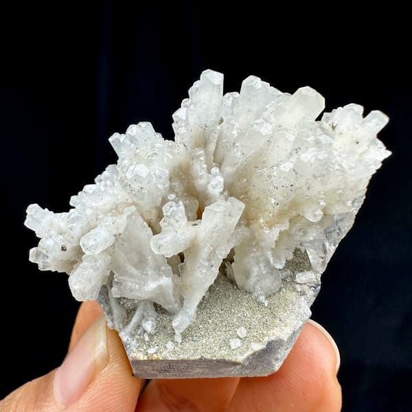 Feather calcite with pyrite, from Shangbao Mine, Hunan, China, front view in daylight, held in hand