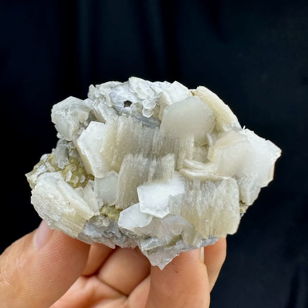 Hexagonal layered calcite, from Yunxiao, Fujian, China, front view in daylight, held in hand