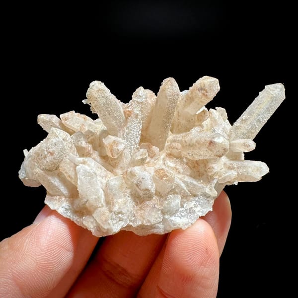 Spiky cluster of pale quartz needles with pyrite from Inner Mongolia, China, held in hand