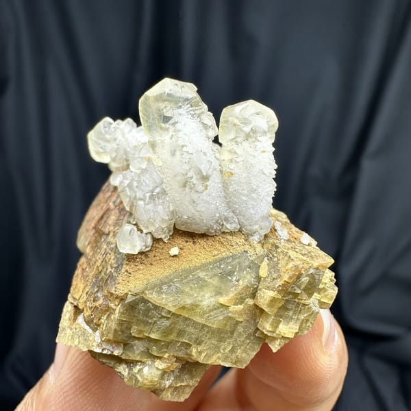 Frosted white calcite prisms on golden siderite block from Guizhou, China, detail of the matrix contact