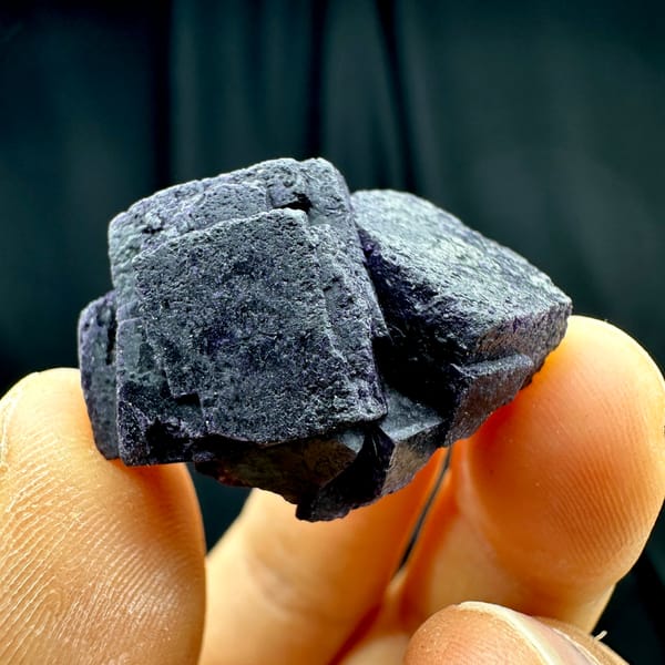 Two black-purple fluorite cubes with matte skin from Inner Mongolia, China, close-up of the crystal faces