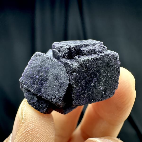 Two black-purple fluorite cubes with matte skin from Inner Mongolia, China, detail of the matrix contact