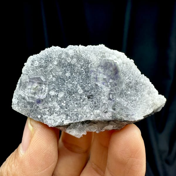 Transparent purple-zoned fluorite dodecahedron on white quartz from Fujian, China, top view