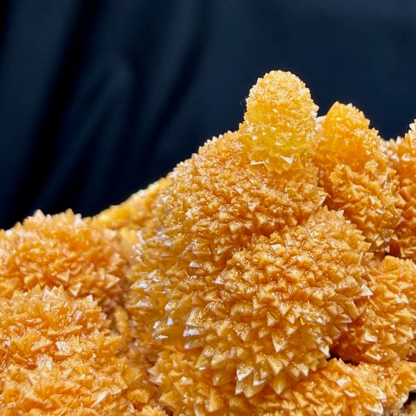 Orange stalactitic calcite mound with sugary skin from Yunnan, China, close-up of the crystal faces