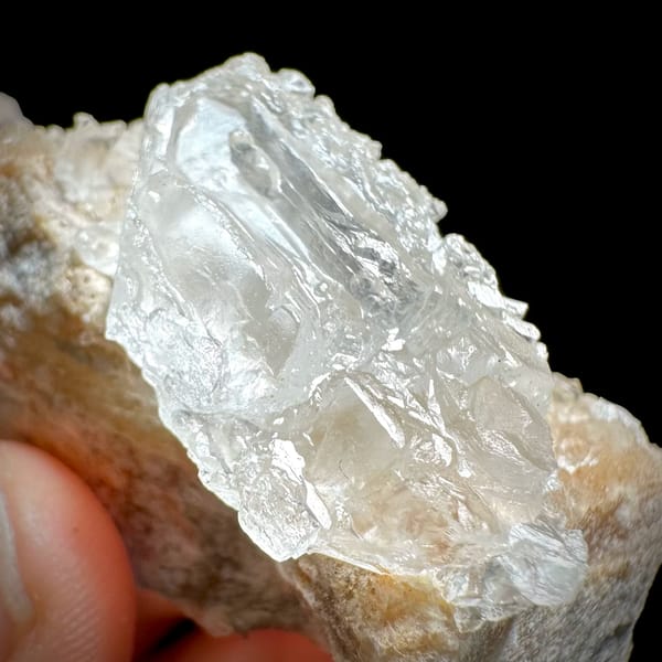 Pale baryte crystal with quartz druse on tan base from Jinkouhe, Sichuan, China, top view