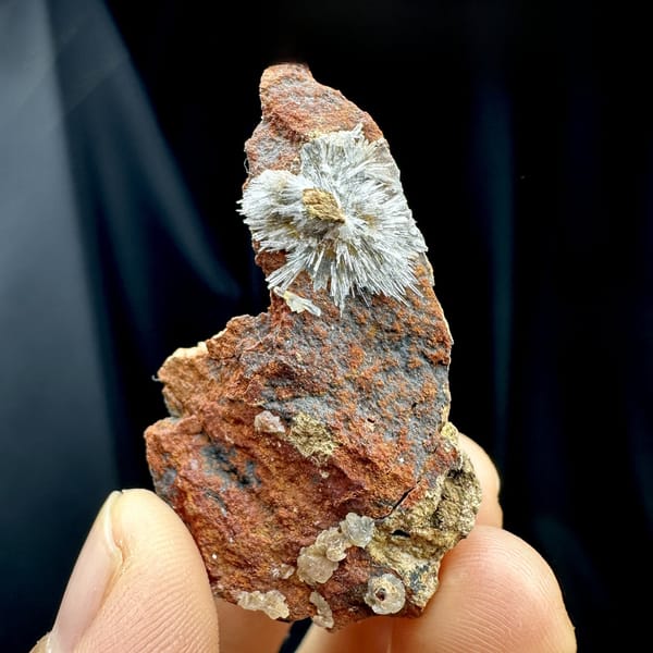 White acicular creedite spray on rust-red wedge from Guizhou, China, close-up of the crystal faces