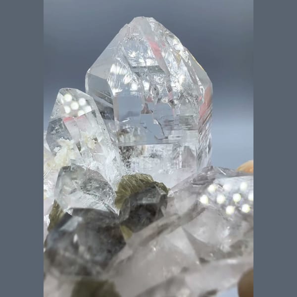 Clear Yaogangxian quartz cluster with scheelite, fluorite and mica — detail view