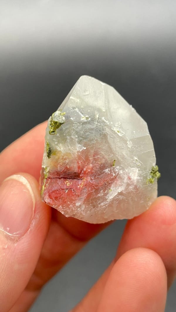 Clear quartz crystal with small green epidote inclusions from Meigu, Sichuan, close-up of the crystal faces