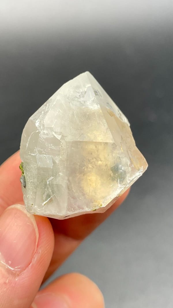 Clear quartz crystal with small green epidote inclusions from Meigu, Sichuan, top view