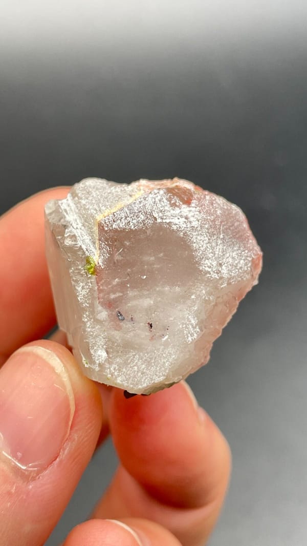 Clear quartz crystal with small green epidote inclusions from Meigu, Sichuan, detail of the matrix contact