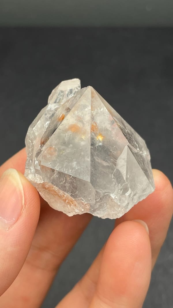 Large clear quartz crystal with rust-orange inclusions from Meigu, Sichuan, China