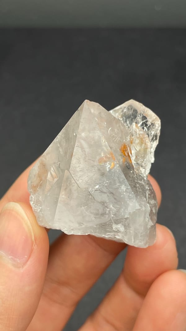 Large clear quartz crystal with rust-orange inclusions from Meigu, Sichuan, China, second angle