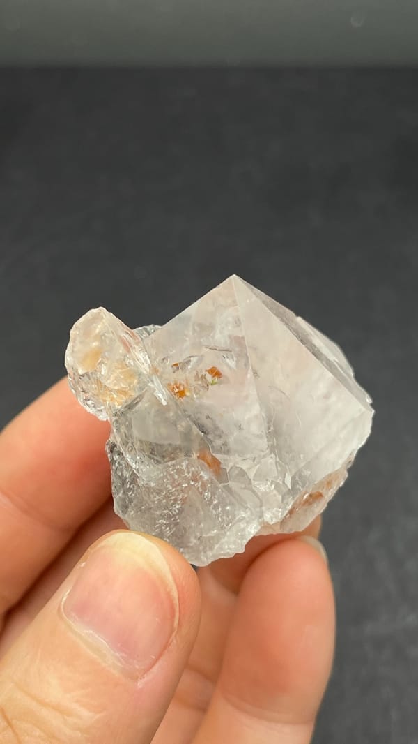 Large clear quartz crystal with rust-orange inclusions from Meigu, Sichuan, China, reverse side