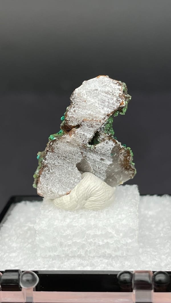 Green conichalcite tufts on a quartz base from Morocco, in a display box, detail of the matrix contact