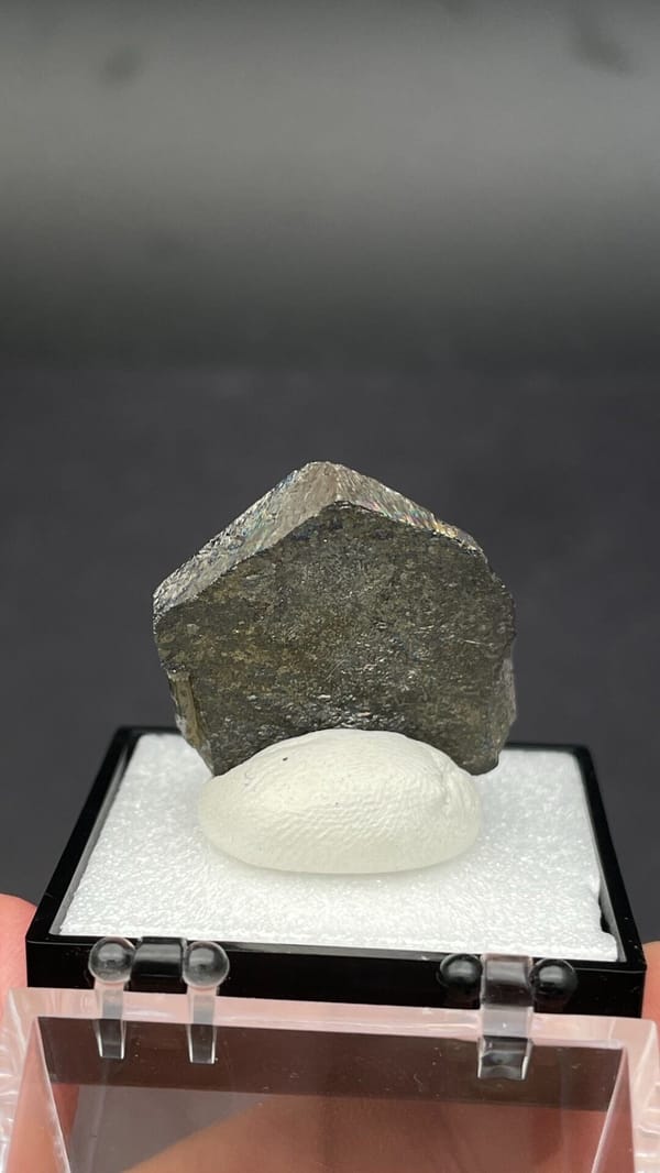 Dark steel-grey magnetite single crystal from Inner Mongolia, China, in a box, detail of the matrix contact