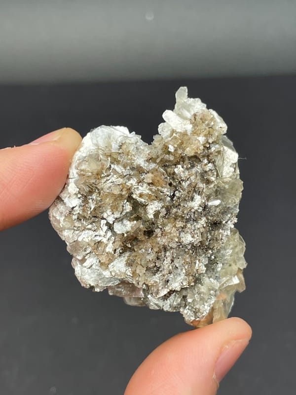 Silvery mica book cluster from Xuebaoding, Sichuan, China, detail of the matrix contact