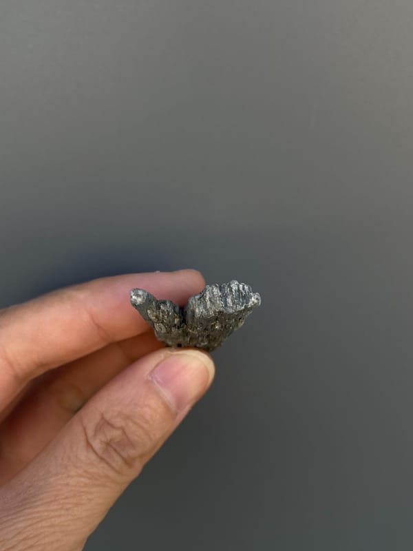 Steel blue-grey bladed kyanite crystal from Madagascar, detail of the matrix contact