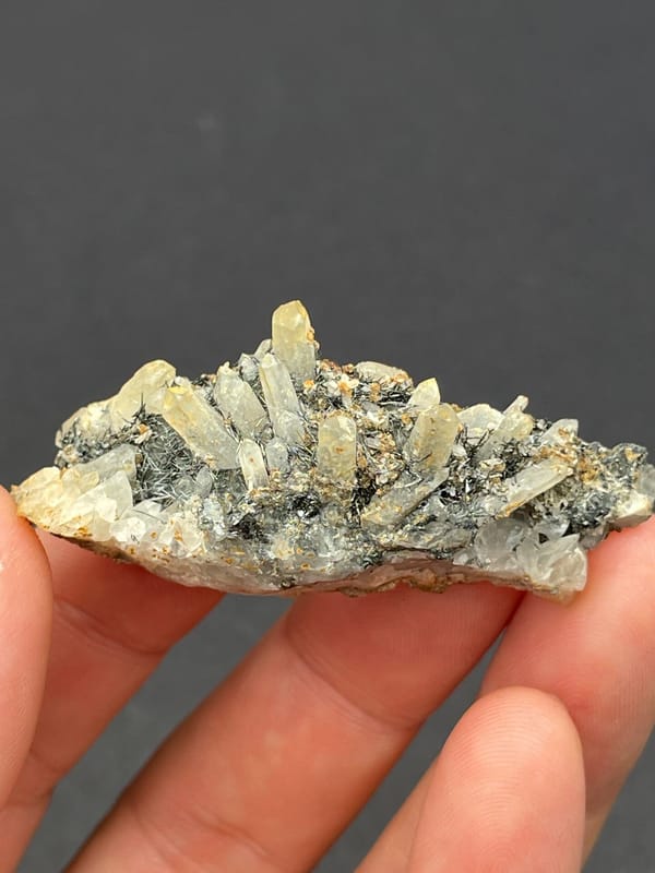 Dark metallic bismuthinite with pale quartz crystals, Inner Mongolia, China