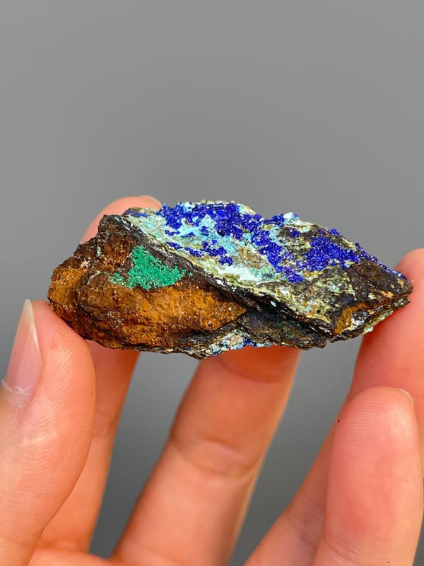 Electric blue azurite with green staining and pale gibbsite, Yunnan, China, close-up of the crystal faces